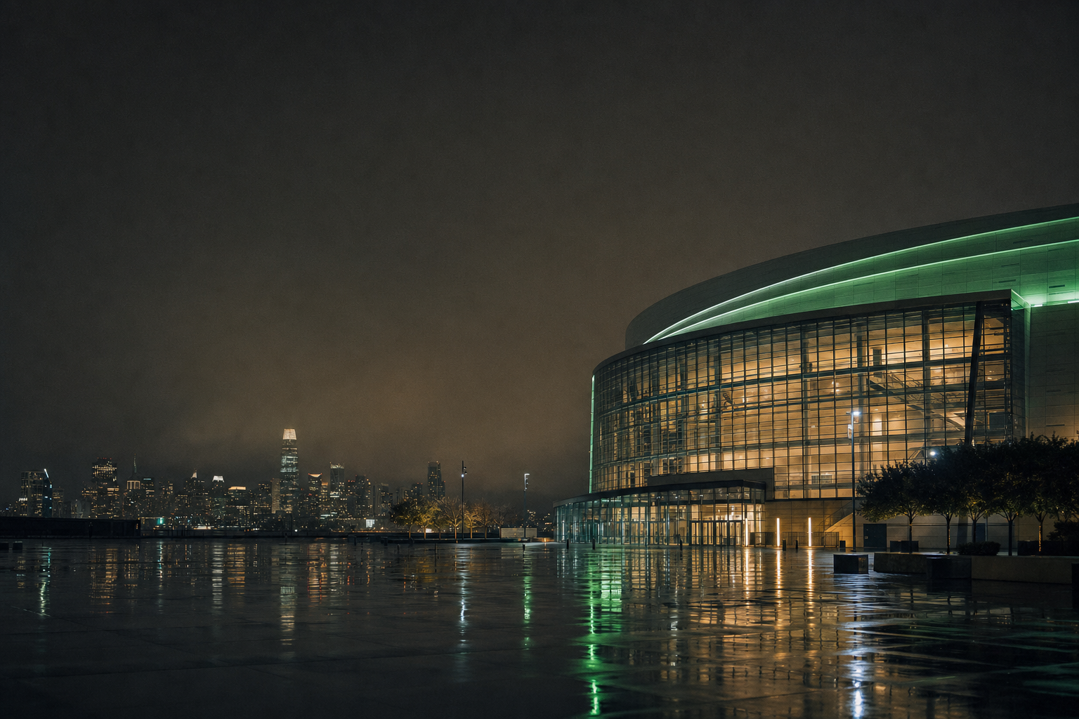 Modern NBA arena at night across an empty wet plaza, San Francisco Bay Area skyline in the distance